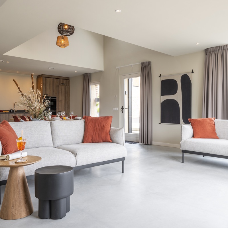 Sfeervol en met designmeubels ingerichte woonkamer van een vakantiehuis in Simpelveld. 